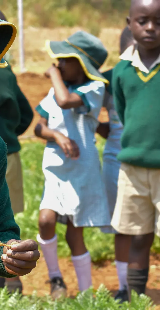 Learners in green uniform in the garden